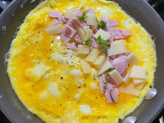 Smażenie omletu z szynką i serem na patelni