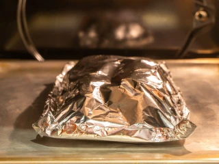 Filet z ryby zawinięty w folię aluminiową w piekarniku