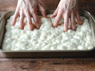 Wyrośnięte ciasto na focaccię w formie do pieczenia