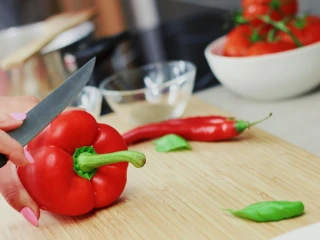 Kobieta kroi czerwoną paprykę
