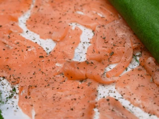 Zwijanie szpinakowych naleśników z zerkiem i łososiem