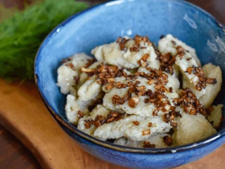 szare kluski podane w niebieskiej miseczce