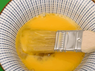 Roztrzepane jajko w pasiastej misce