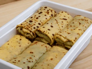 Zawinięte naleśniki ze szpinakiem i serem fetą w białym pudełku