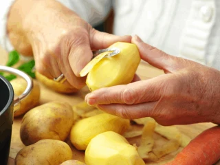 Kobieta obierająca ziemniaki