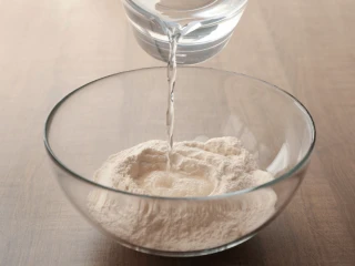 Woda wlewana do miski z mąką