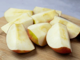Jabłka pokrojone na ćwiartki na drewnianej desce