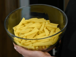 Ziemniaki pokrojone na frytki w szklanej misce