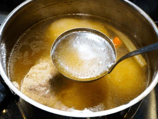 Łyżka wazowa z ugotowanym rosołem