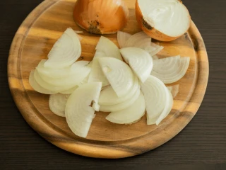 Pokrojona w piórka cebula na drewnianej desce