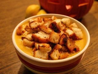 Miska gęstej zupy serowej obficie posypanej chrupiącymi grzankami