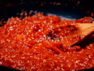 Sos chili mieszany drewnianą łyżką