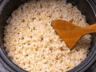 Ugotowany brązowy ryż w czarnym garnku