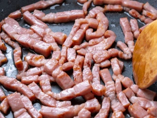 Boczek pokrojony w paski podsmażany na patelni