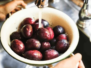 Śliwki myte na durszlaku