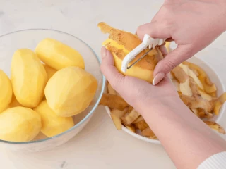 Kobieta obierająca ziemniaki