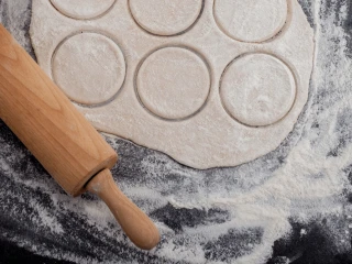 Rozwałkowane ciasto z wykrojonymi kółkami na pierogi
