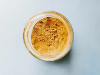 Szklany słoik widziany z góry, wypełniony przyprawą curry