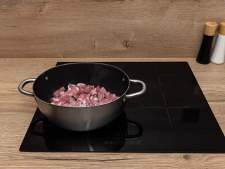 Osoba kroi boczek na drewnianej desce