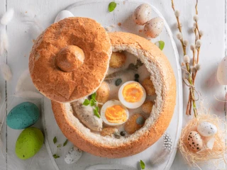 Wielkanocny barszcz biały z jajkiem i białą kiełbasą podany w chlebie