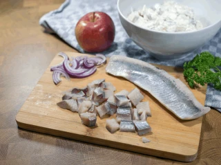 Pokrojone śledzie na drewnianej desce