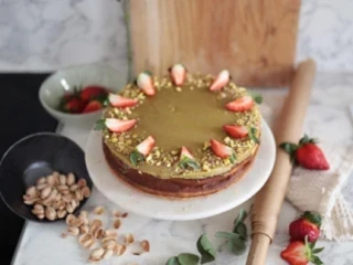 Sernik pistacjowy ozdobiony truskawkami