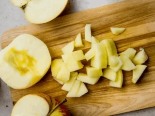 Pokrojone w kostkę jabłka na drewnianej desce