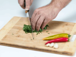 Zbliżenie na ręce mężczyzny przygotowującego składniki na spaghetti aglio olio e peperoncino