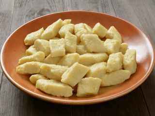 Ugotowane kopytka na pomarańczowym talerzu