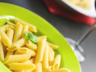 Ugotowany makaron penne w zielonym talerzu