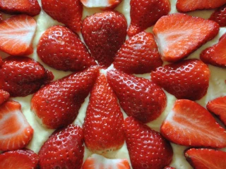 Truskawki ułożone na surowym cieście