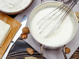 Garnek z sosem beszamelowym i rózgą do mieszania