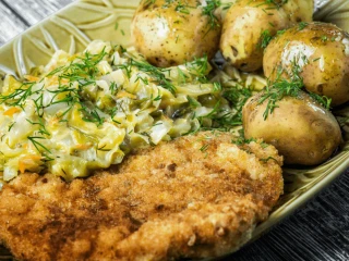 Kotlet schabowy podany z młodymi ziemniakami i kapustą zasmażaną
