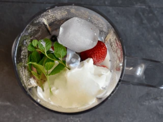 skyr, lód, mięta i owoce w kielichu blendera