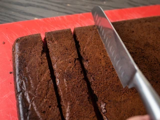 Zbliżenie na osobę krojącą brownie na kawałki