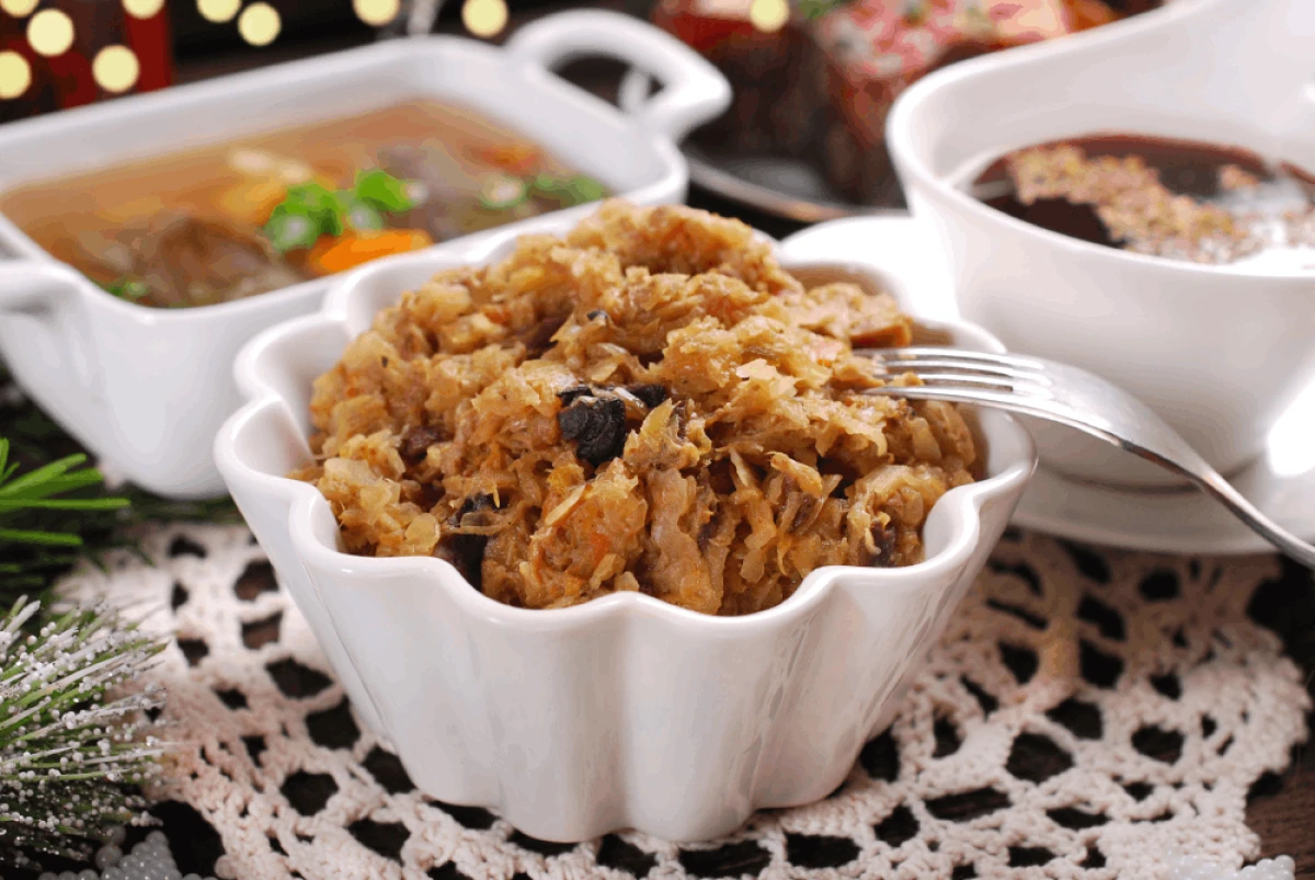 Bigos z kapusty kiszonej w białej misce stojący na udekorowanym stole