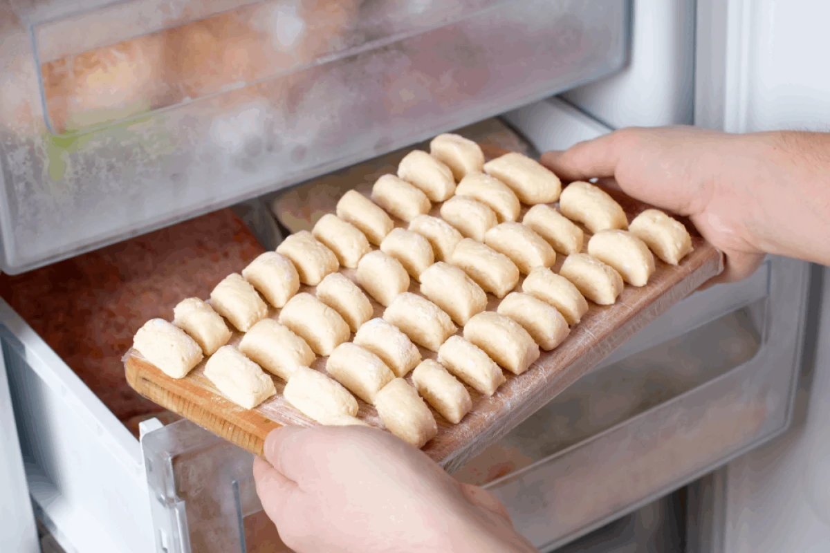 Kobieta wkłada pierogi leniwe do zamrażarki
