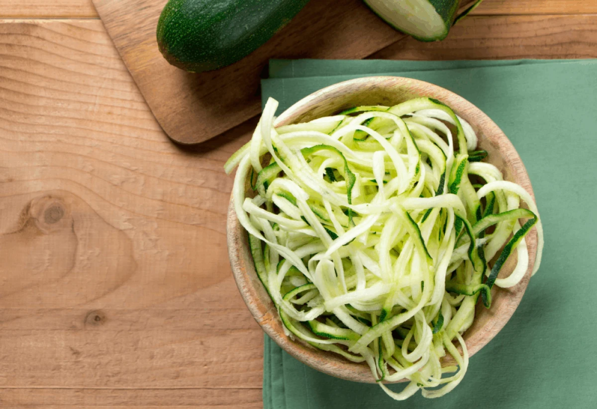 Makaron z cukinii w drewnianej misce stojący na blacie w kuchni