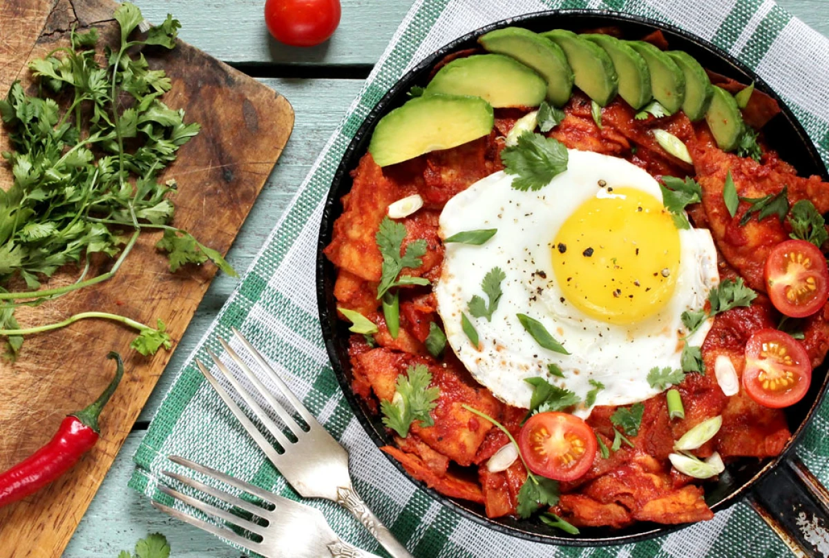 Meksykańskie danie w patelni: nachosy w sosie pomidorowo-paprykowym z jajkiem sadzonym, awokado, pomidorkami koktajlowymi i świeżą kolendrą