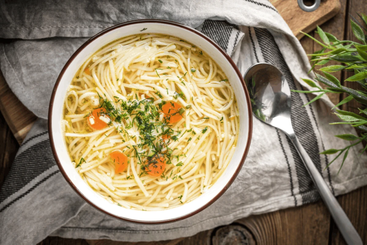 Rosół z domowych makaronem i marchewką posypany koperkiem