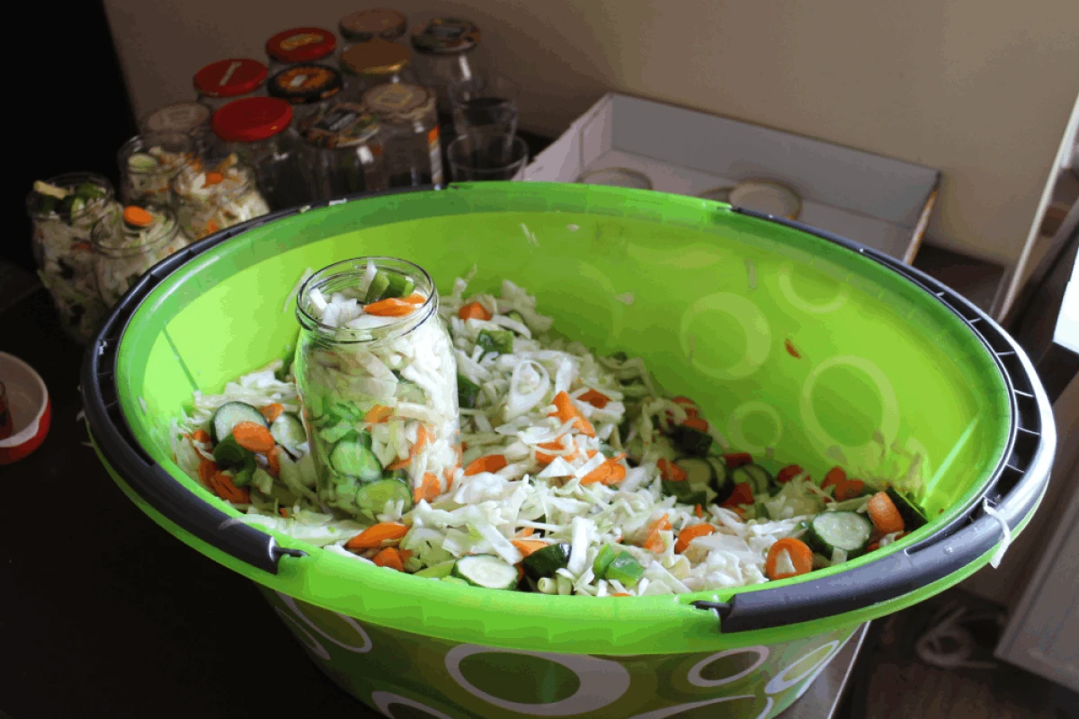 Sałatka wielowarzywna w zielonej misce nakładana do słoika