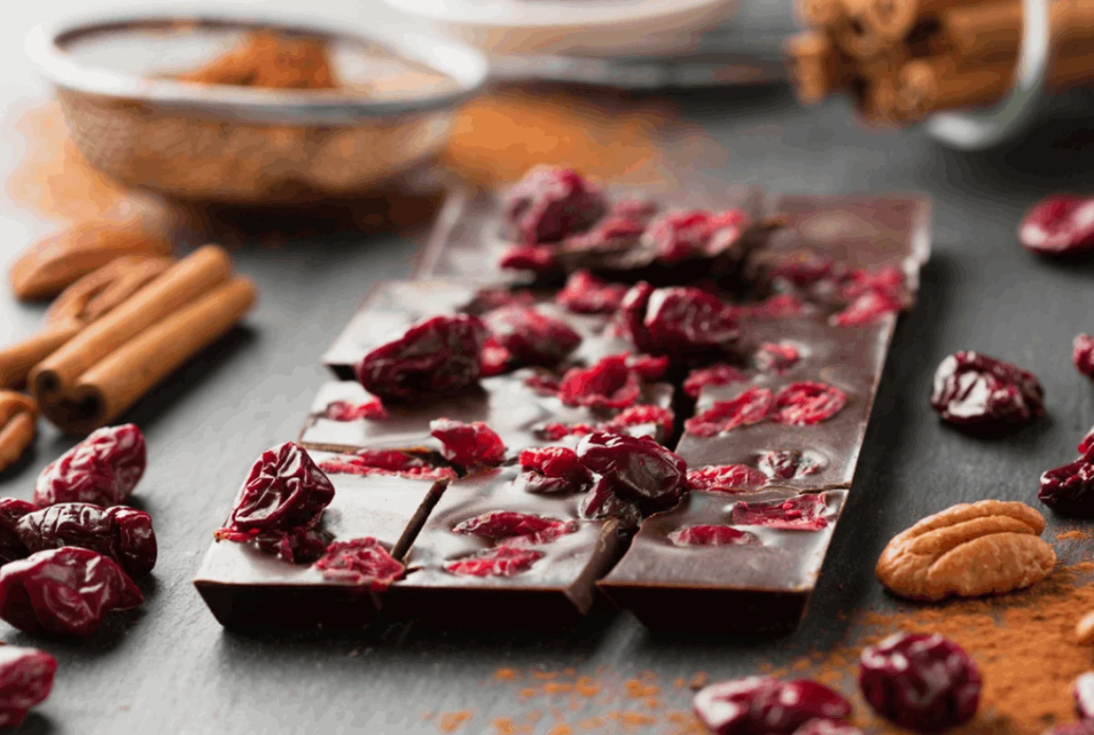 Tabliczka domowej czekolady z żurawiną leżąca na kuchennym blacie