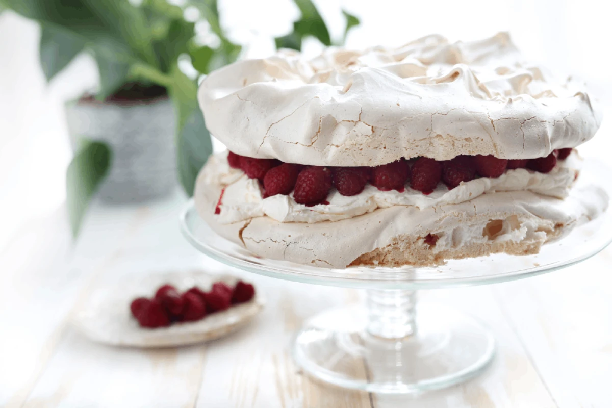 Tort bezowy z malinami podany na paterze