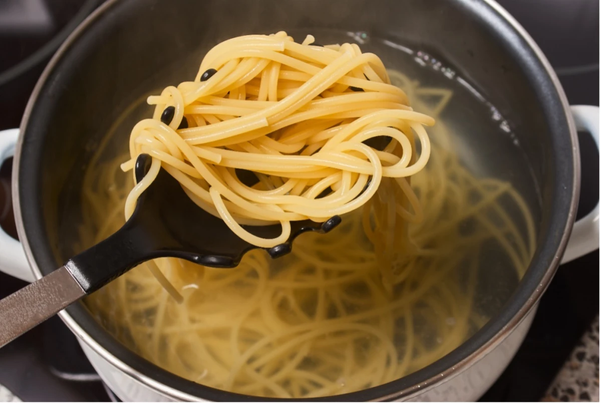 Ugotowany makaron spaghetti na łyżce cedzakowej