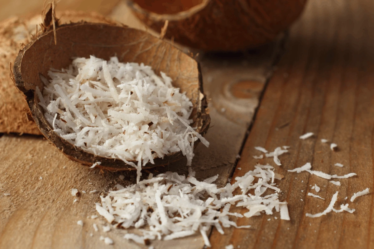 Wiórki kokosowe rozsypane na drewnianym blacie