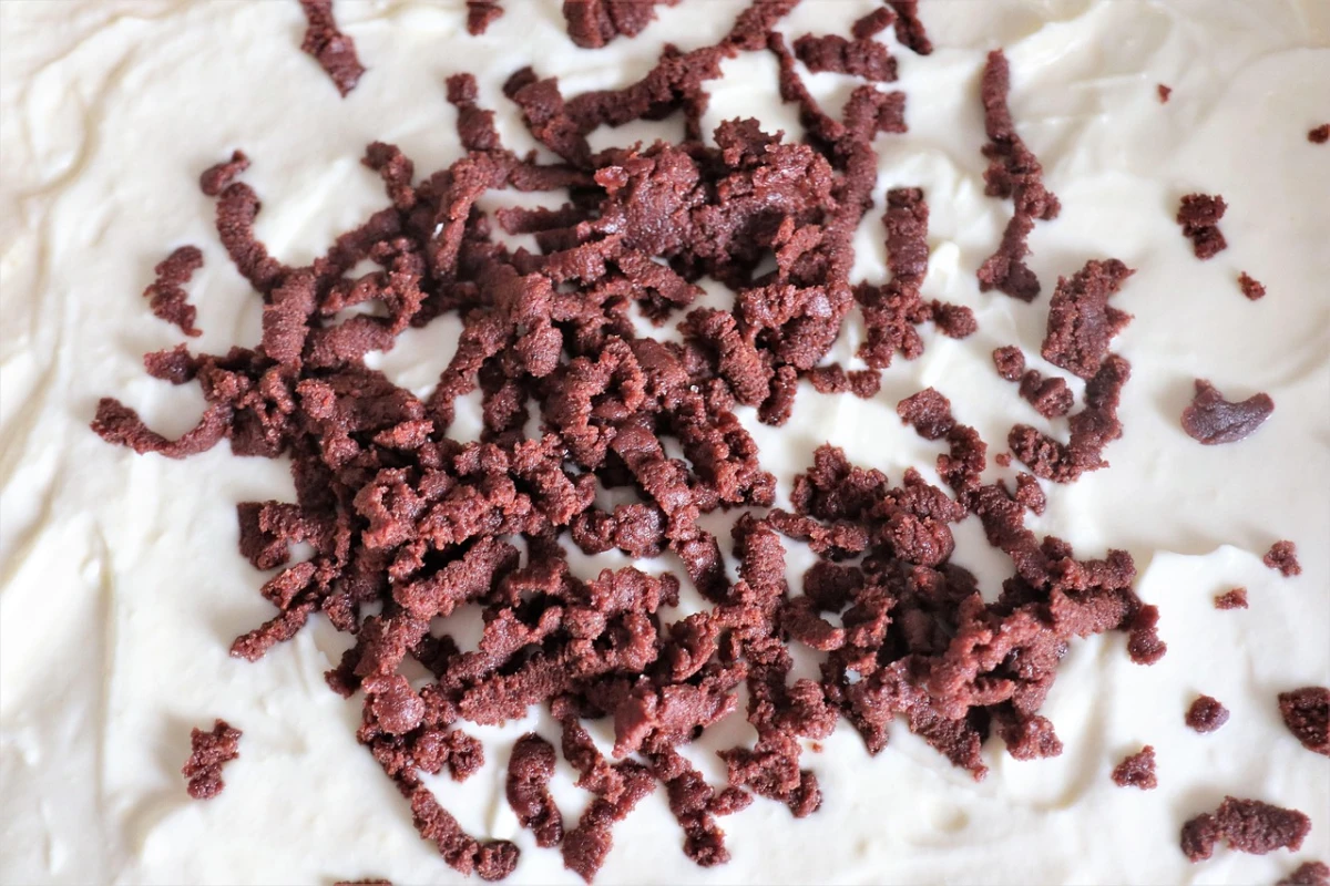 Zbliżenie na czekoladową kruszonkę rozsypaną na ubitych białkach