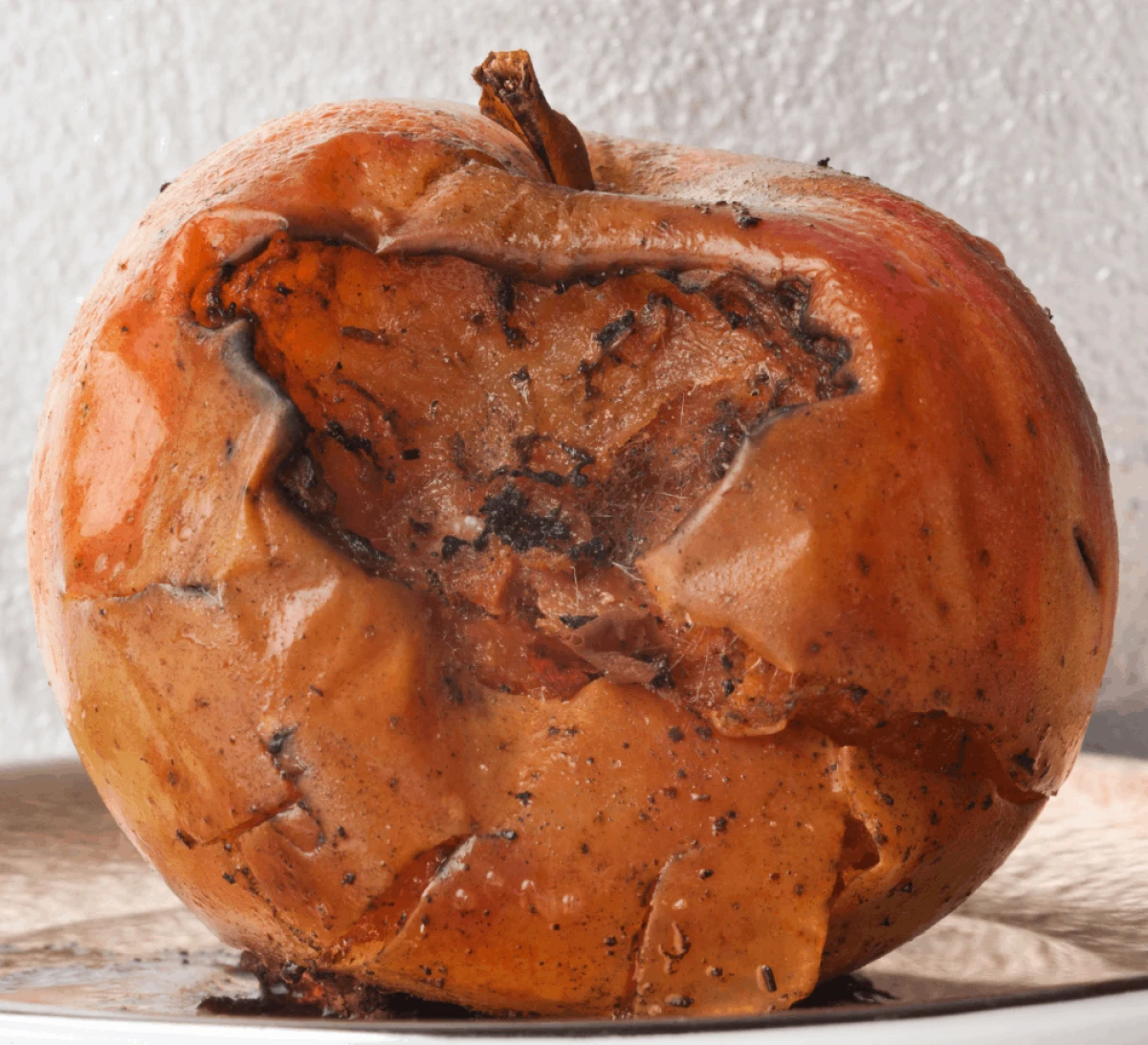 Zbliżenie na zgniłe jabłko z muszkami