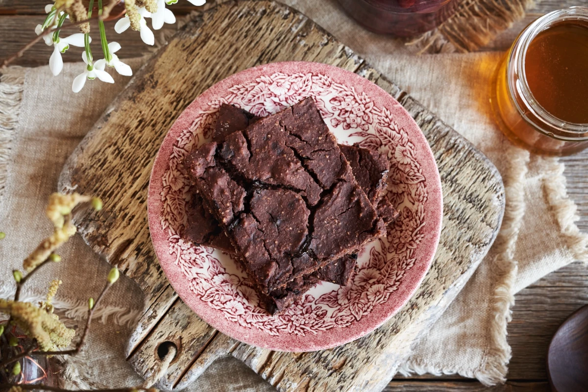 Kawałek czekoladowego brownie z czerwonej fasoli podany na różowym talerzyku