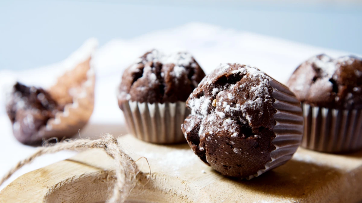 Muffinki czekoladowe z wiśniami posypane cukrem pudrem